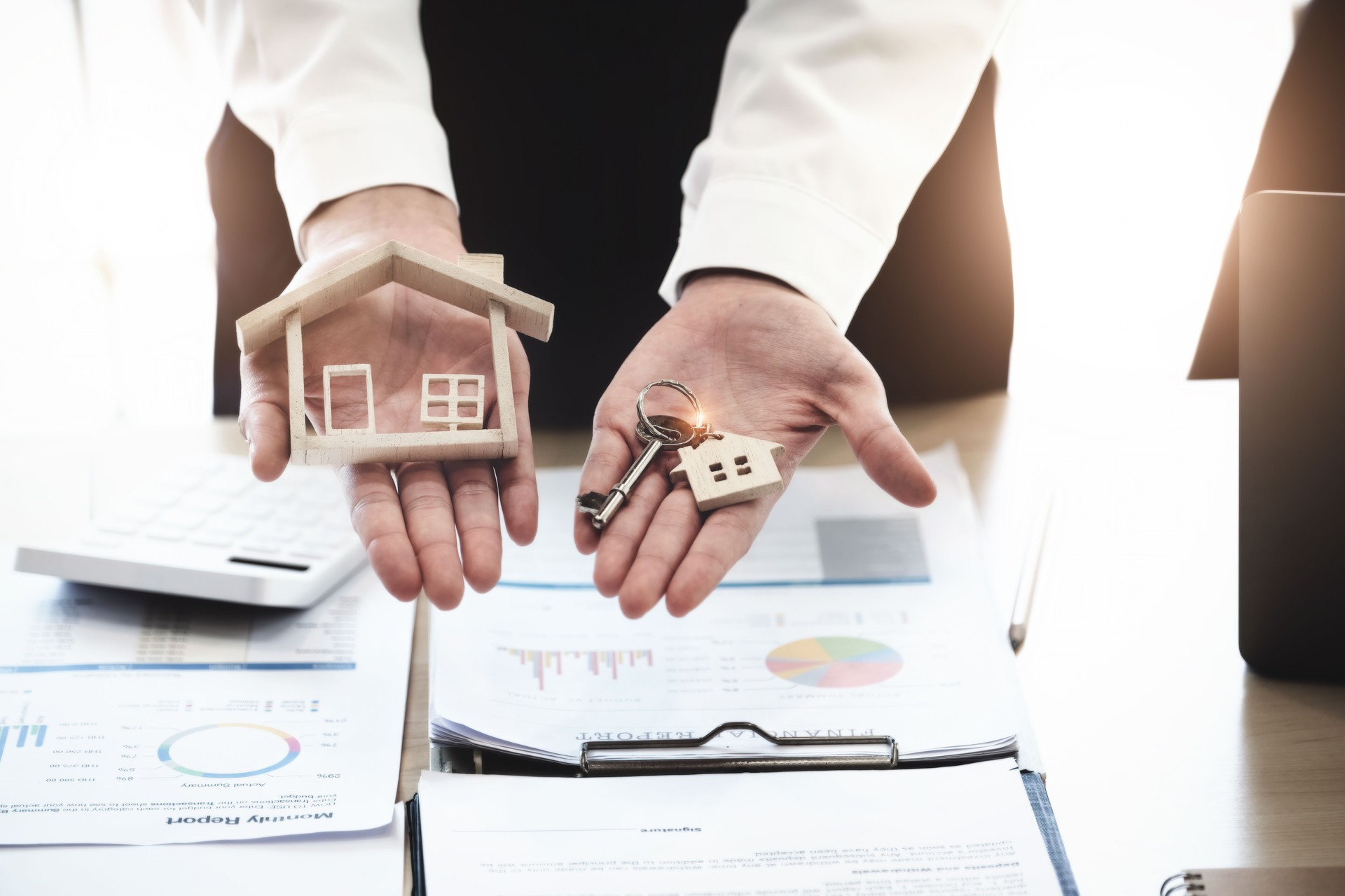 Les agents immobiliers acceptent d’acheter une maison et de donner les clés aux clients dans les bureaux de leur agence. Accord conceptuel.