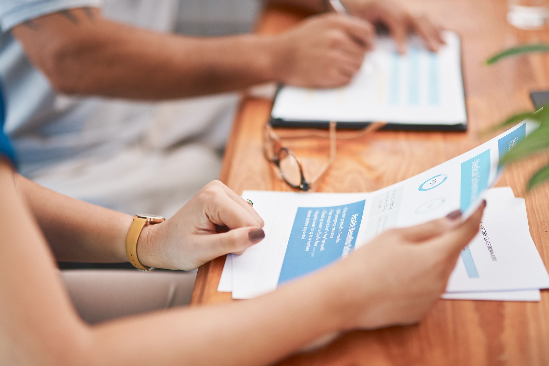 Mains, documents et couple avec paperasse pour l’hypothèque, le contrat ou la vente immobilière. Mariage, finances et personnes dans un cabinet d’avocats pour des conseils juridiques, de l’aide ou des conseils en matière de prêt, d’assurance ou