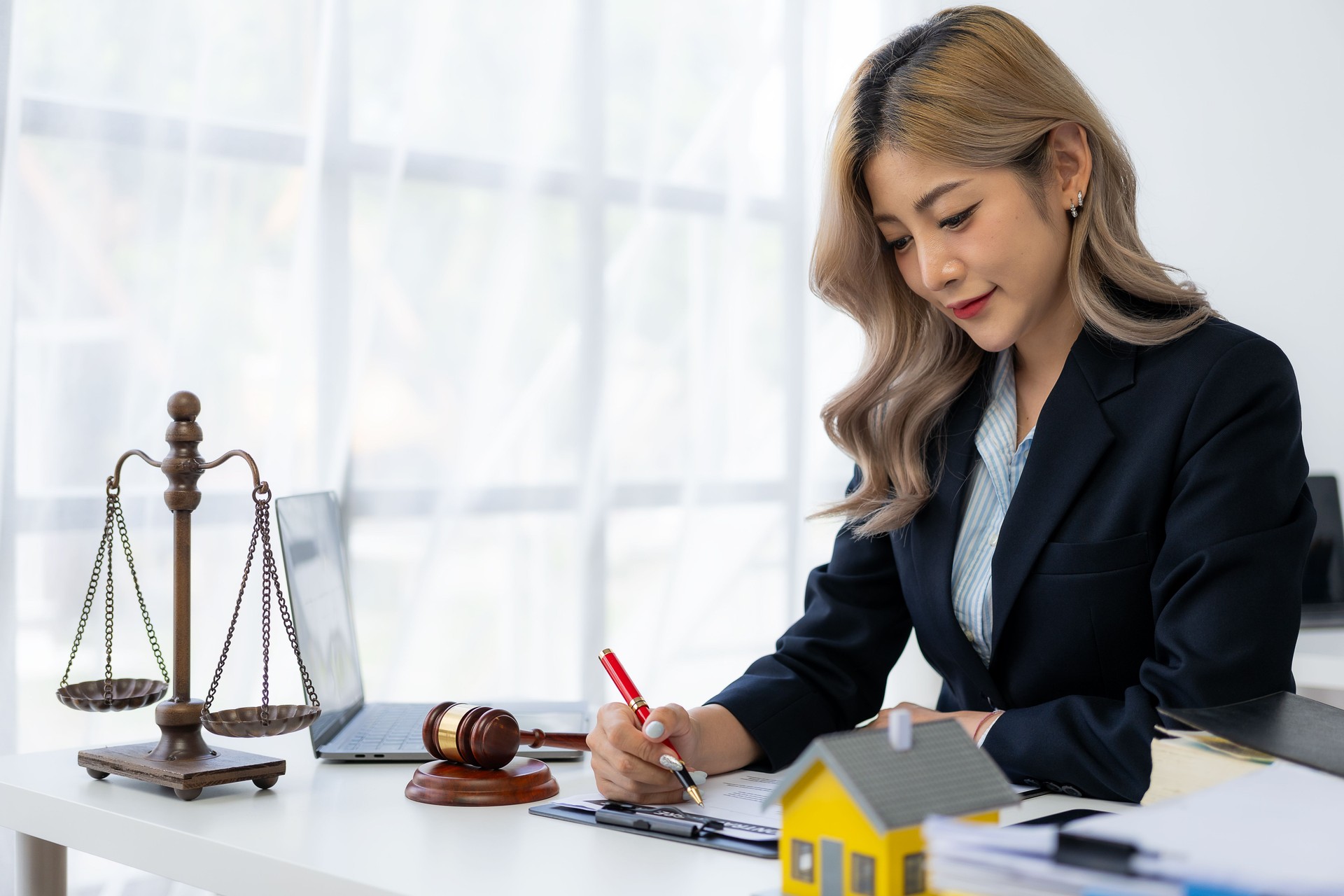 Vente aux enchères immobilière Main de la femme tenant le marteau et la maison modèle, avocat immobilier dans la vente de maisons, le financement et la forclusion, concept de propriété.
