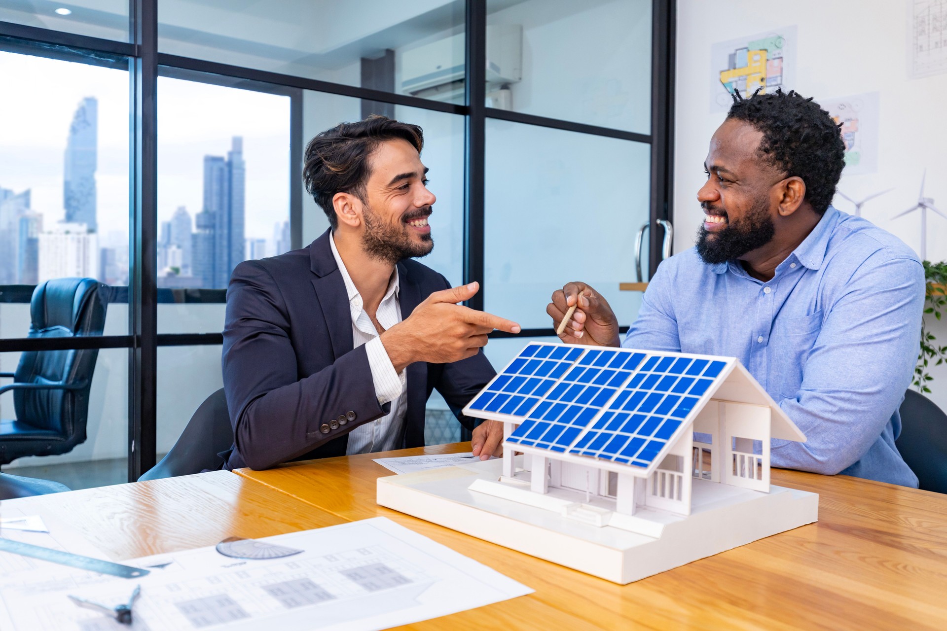 Une équipe d’architectes et d’hommes d’affaires discute et réfléchit à la modification du plan d’étage pour un projet d’investissement durable dans l’immobilier et de développement de logements à énergie solaire