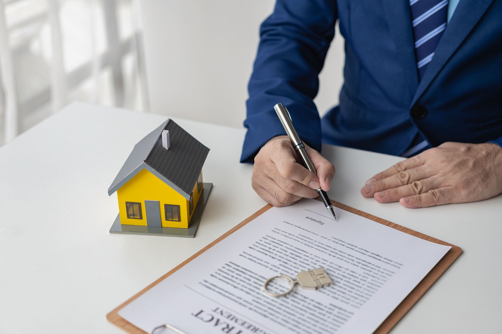 Conseiller en vente de maison et assurance, agent immobilier travaillant avec des documents contractuels et un ordinateur portable au bureau